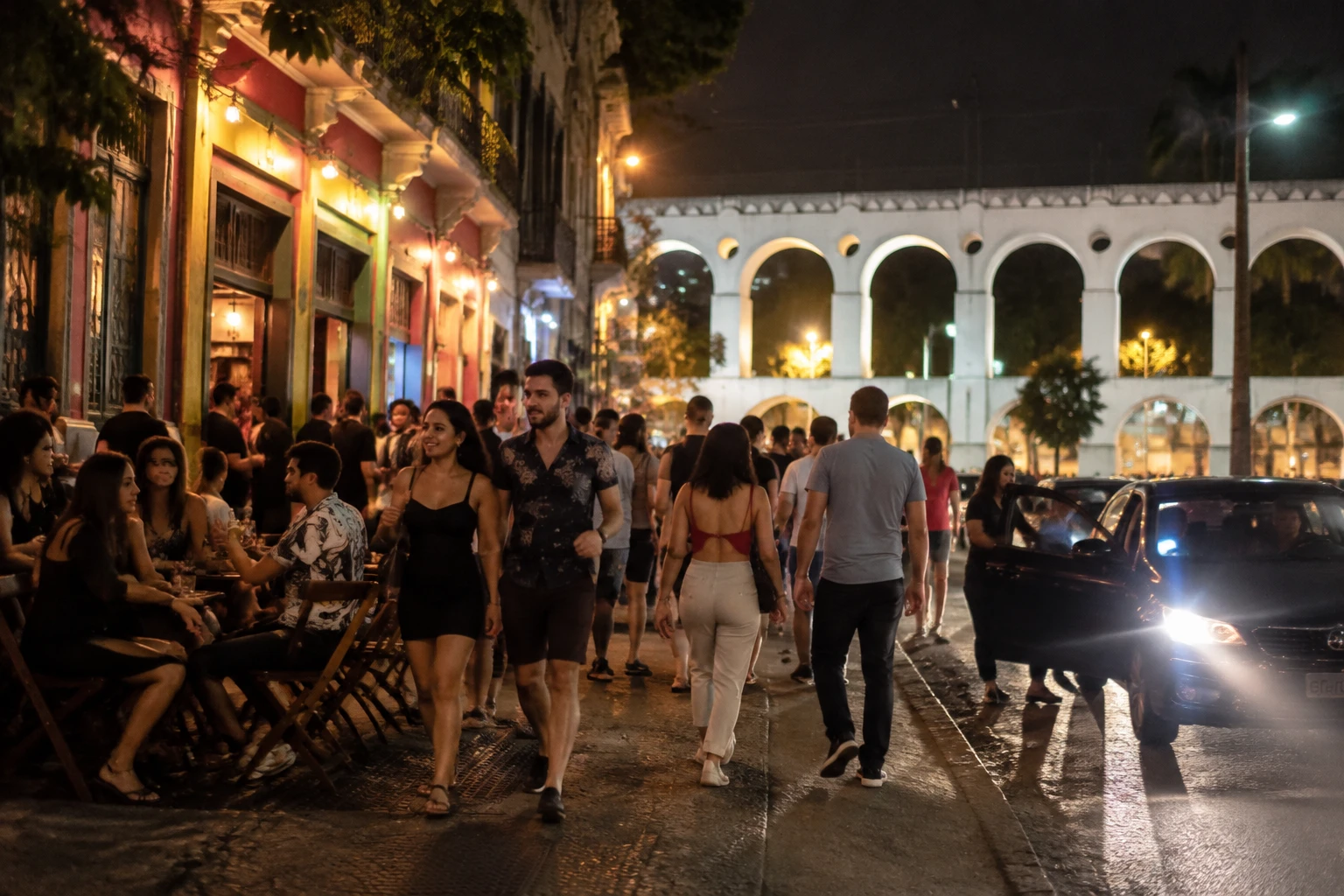 Active Lapa nightlife street with a curbside pickup point at night
